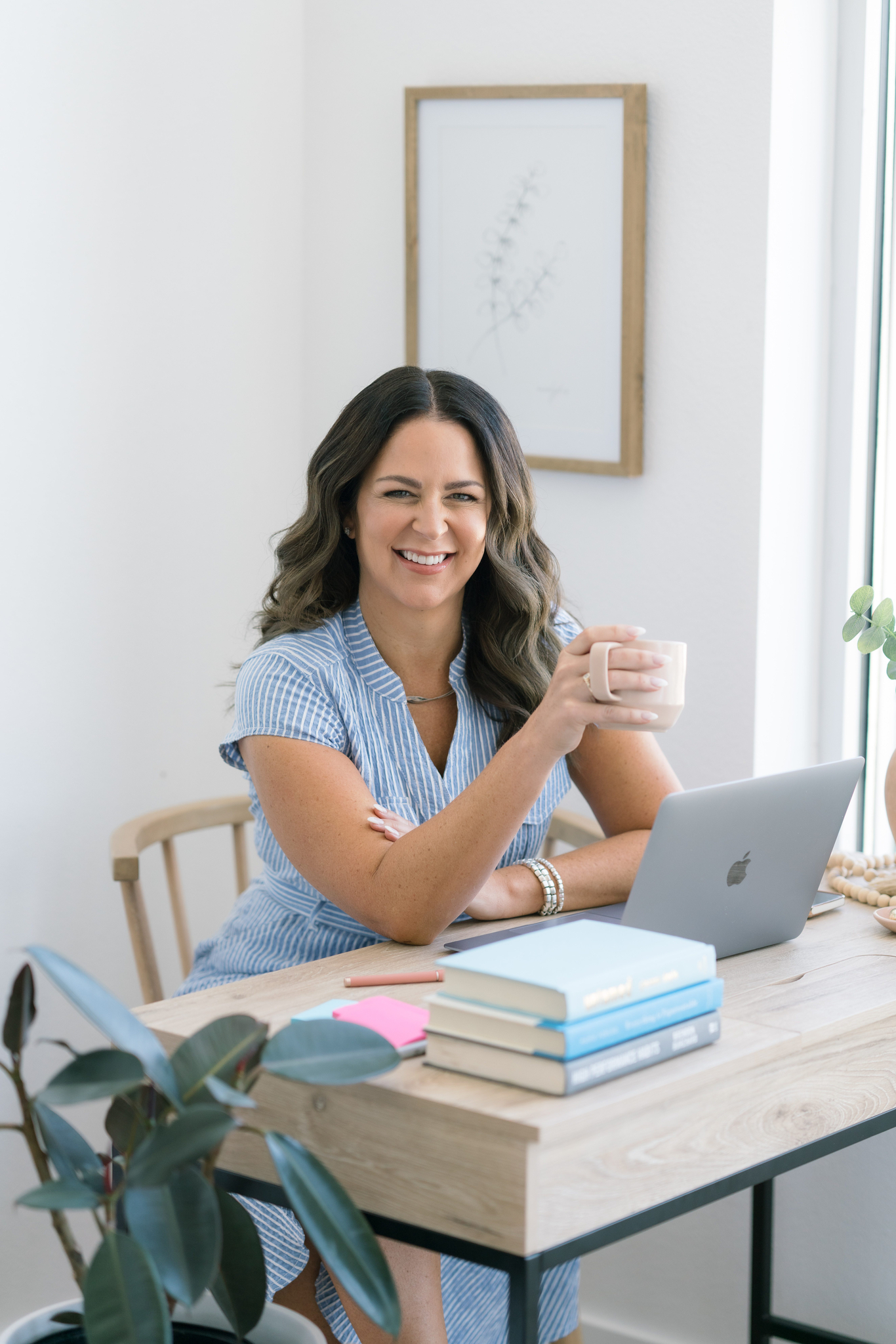 Shayla King, executive life coach looks up from her laptop and smiles while holding a cup of coffee